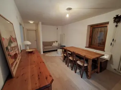 a living room with a wooden table and chairs at La Casa di Elvira-Primo Piano in Alleghe