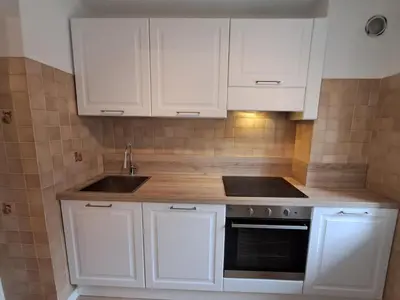 a kitchen with white cabinets and a sink at La Casa di Elvira-Primo Piano in Alleghe