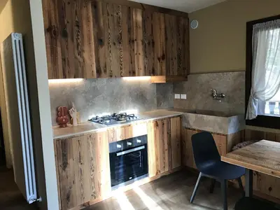 a kitchen with wooden cabinets and a stove at Masiere - La Chicca in Masarè