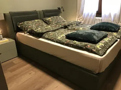 a bed with a black frame and pillows on it at Masiere - La Chicca in Masarè