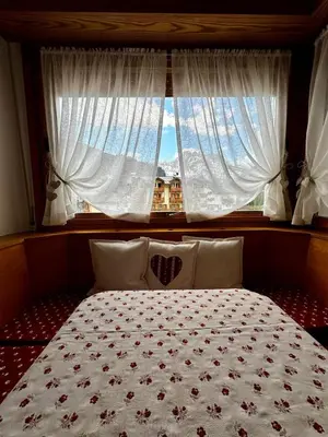 a bedroom with a bed with a window at Da Benny in Caprile