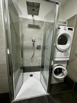 a shower stall in a bathroom with a washing machine at Da Benny in Caprile