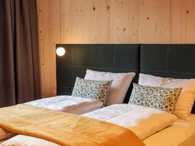 a bedroom with a large bed with pillows at Kreithner luxury apartments in Vandoies