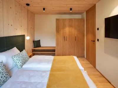 a bedroom with a large bed and a tv at Kreithner luxury apartments in Vandoies