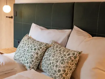 a pile of pillows sitting on top of a bed at Kreithner luxury apartments in Vandoies