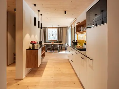 a kitchen with a long hallway leading to a dining room at Kreithner luxury apartments in Vandoies