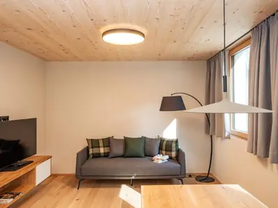 a living room with a couch and a table at Kreithner luxury apartments in Vandoies