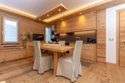 a wooden kitchen with a wooden table and chairs at Alpine Nest in Rocca Pietore