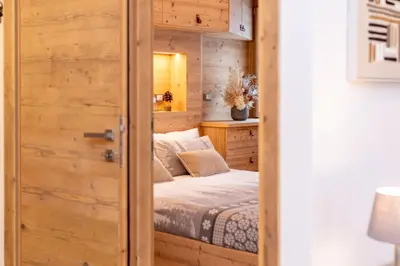a bedroom with a bed inside of a wooden door at Alpine Nest in Rocca Pietore