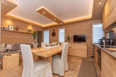 a kitchen and dining room with a wooden table and chairs at Alpine Nest in Rocca Pietore