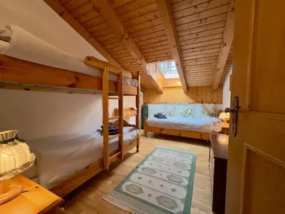 a bedroom with two bunk beds and a desk at L'Antico Fienile - Val di Fiemme in Daiano