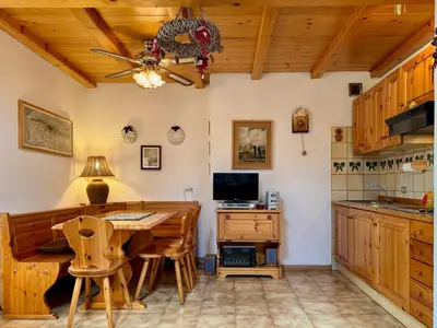 a kitchen with a table and a ceiling fan at L'Antico Fienile - Val di Fiemme in Daiano