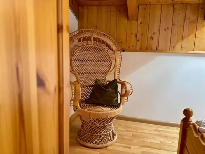 a wicker chair with a pillow in a room at L'Antico Fienile - Val di Fiemme in Daiano
