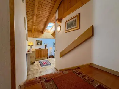 a hallway of a home with a kitchen and a staircase at L'Antico Fienile - Val di Fiemme in Daiano