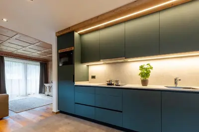 a kitchen with dark blue cabinets and a sink at Ciasa Francësch in La Villa