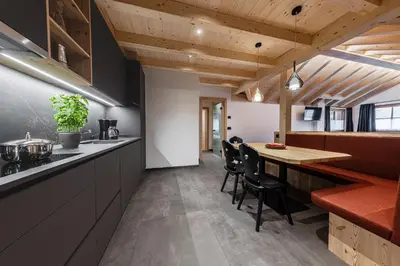 a kitchen and dining room with a table and chairs at Ciasa Francësch in La Villa