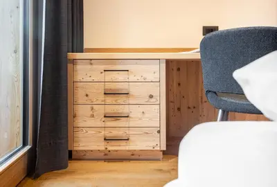 a wooden dresser with a desk and a chair at Ciasa Francësch in La Villa