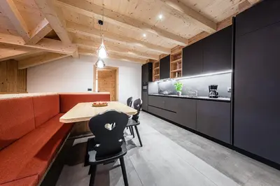 a kitchen and dining room with a table and chairs at Ciasa Francësch in La Villa