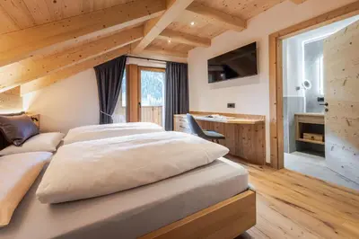 a bedroom with a bed and a desk in a room at Ciasa Francësch in La Villa