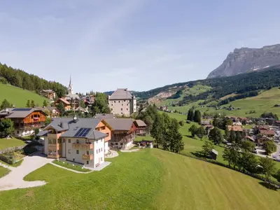 an aerial view of a house on a green hill at Ciasa Francësch in La Villa