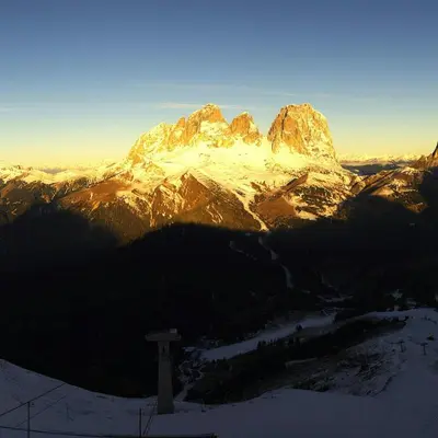 a mountain with snow on it with the sun shining on it at Appartamento Ivo in Campitello di Fassa