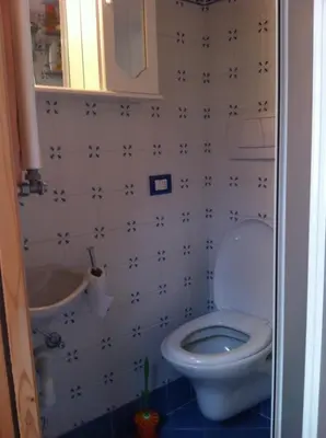 a small bathroom with a toilet and a sink at Appartamento Ivo in Campitello di Fassa