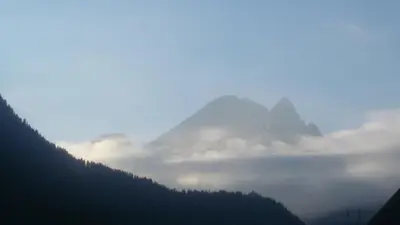 a view of a mountain with clouds in the valley at Appartamento Ivo in Campitello di Fassa