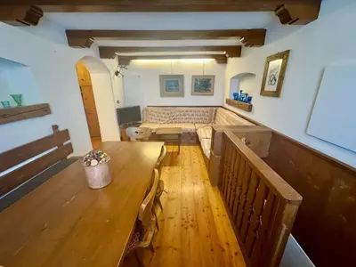 a dining room with a wooden table and a bench at Cozy Apartment - Alverà in Cortina dʼAmpezzo