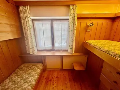 a small room with a window and two beds at Cozy Apartment - Alverà in Cortina dʼAmpezzo