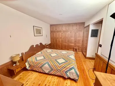 a bedroom with a bed in a room with wooden floors at Cozy Apartment - Alverà in Cortina dʼAmpezzo