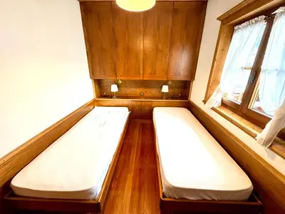two beds in a small room with a window at Ca Montagni - High-end apartment Verocai in Cortina dʼAmpezzo