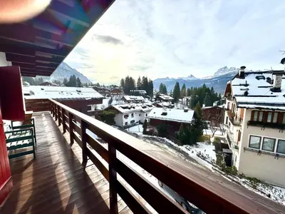 a balcony with a view of a snow covered city at Ca Montagni - High-end apartment Verocai in Cortina dʼAmpezzo
