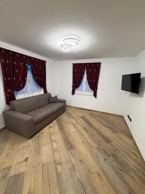 a living room with a couch and a television at Chalet La Viola in Alba di Canazei
