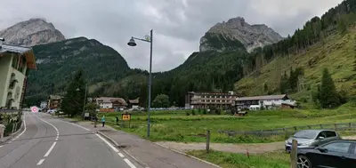 a street light on the side of a road with mountains at Chalet La Viola in Alba di Canazei