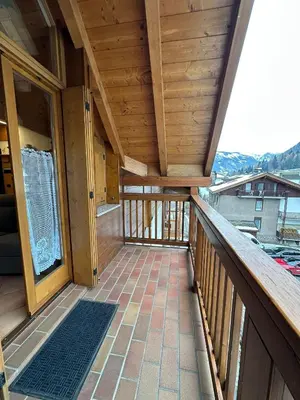 a large balcony with a view of a house at Appartamento Pelenzana in Predazzo