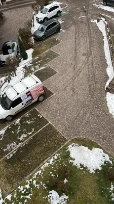 two cars parked in a parking lot with snow at Appartamento Pelenzana in Predazzo