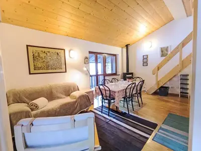 a bedroom with a large bed and a chair at Apartment Genziana-5 by Interhome in Penia