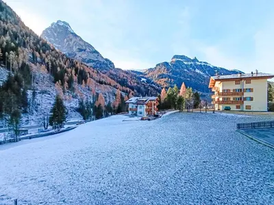 a resort with a snow covered field and mountains at Apartment Genziana-5 by Interhome in Penia