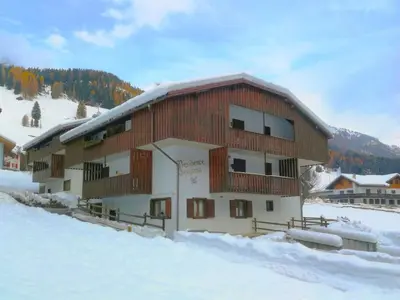a building with a mountain in the background at Apartment Genziana-5 by Interhome in Penia