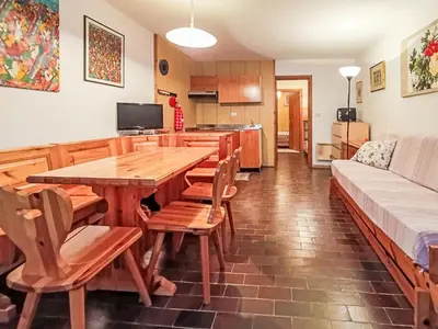 a kitchen and dining room with a wooden table and chairs at Apartment Appartamento Matilde by Interhome in Penia