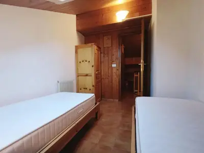 a bedroom with two beds and a door to a hallway at Apartment Des Alpes-19 by Interhome in Campitello di Fassa