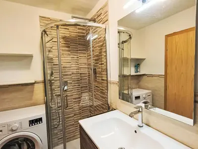 a bathroom with a sink and a washing machine at Apartment Nuccia Navalge by Interhome in Moena