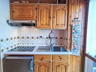a kitchen with wooden cabinets and a sink at Apartment Nuccia Navalge by Interhome in Moena