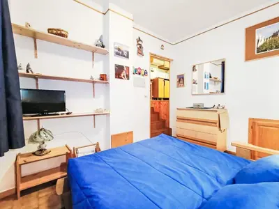 a bedroom with a blue bed and a window at Apartment Solaria-5 by Interhome in Mazzin