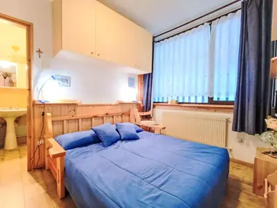 a bedroom with a blue bed in a room at Apartment Solaria-5 by Interhome in Mazzin