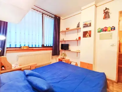 a bedroom with a blue bed and a sink at Apartment Solaria-5 by Interhome in Mazzin
