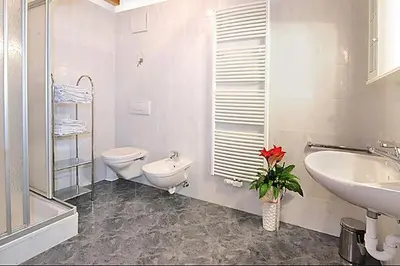 a white bathroom with a toilet and a sink at Apartment Walder in Fiumes