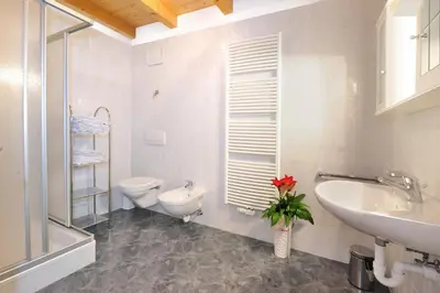 a white bathroom with a toilet and a sink at Apartment Walder in Fiumes