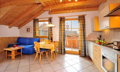 a kitchen and living room with a blue couch and a table at Apartment Walder in Fiumes
