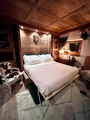 a bedroom with a large bed in a room at Ciasa de Len Cortina in Cortina dʼAmpezzo